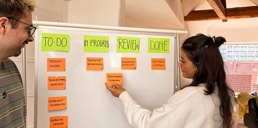 Jana und Christopher arbeiten mit der Arbeitsmethode SCRUM am Whiteboard